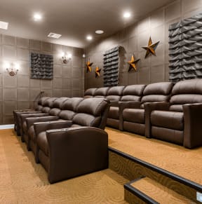 a cinema room with brown leather couches and chairs