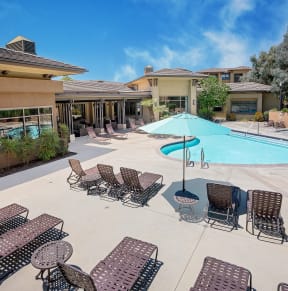 a pool with lounge chairs and umbrellas at the enclave at woodbridge apartments in sugar
