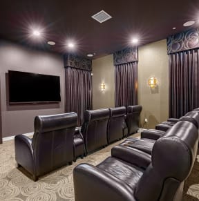 a large screening room with leather seats and a large screen tv