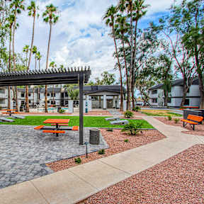 A patio with a table and chairs is surrounded by trees.