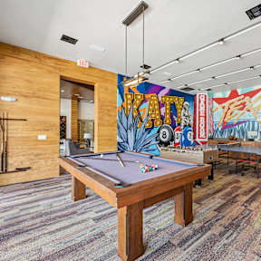 A room with a pool table and a tv.