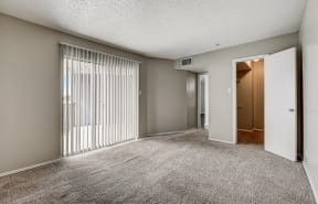 a bedroom with a sliding glass door and carpeted flooring