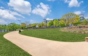 A park with a paved pathway and a grassy area.