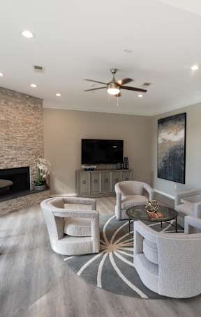 a living room with chairs and a table and a television