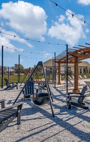 A sunny day at the pool with a wooden pergola and lounge chairs.