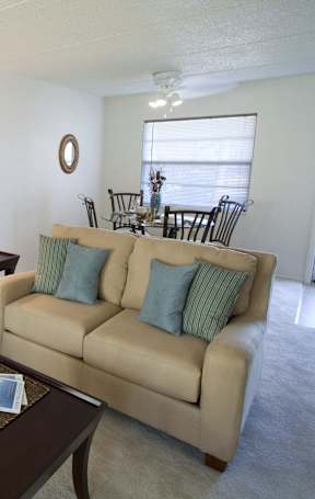 A white bathroom with a toilet, sink, and shower. at Imperial Gardens Apartments, Clearwater, FL, 33764