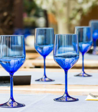 a row of blue wine glasses on a table