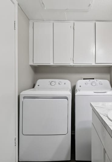 A kitchen with a stove, refrigerator, and sink.
