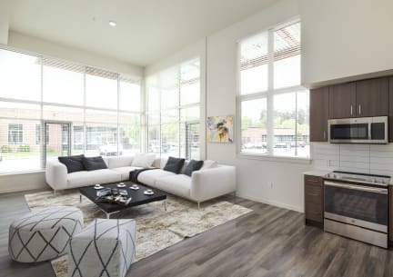 a living room with a couch and a coffee table in front of large windows