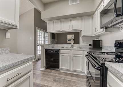 a kitchen with a sink and a refrigerator at The Manhattan Apartments, Dallas, TX, 75252