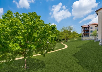 a path through the grass next to a building