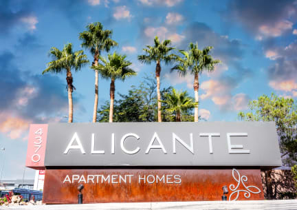 a sign for alicante apartment homes with palm trees