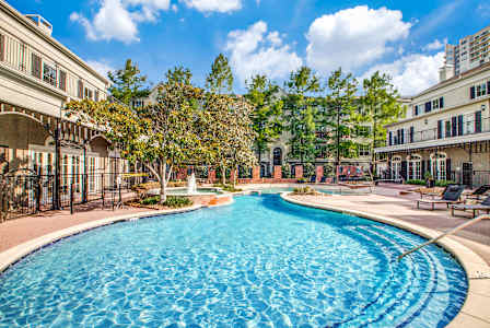 A large swimming pool in the middle of a resort area.