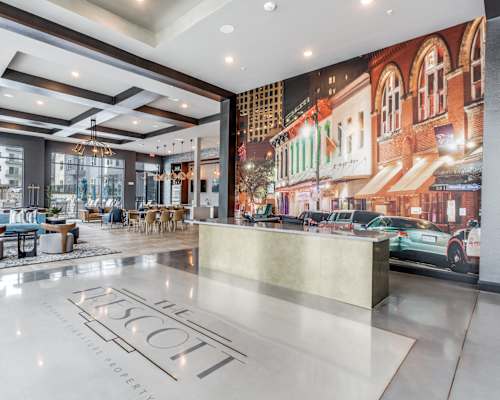 a lobby with a reception desk and a large mural on the wall
