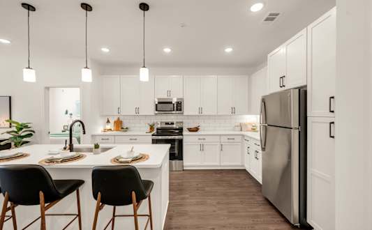 A modern kitchen with a white color scheme and a large island.