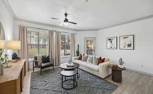 A dining room with a round wooden table surrounded by grey chairs.