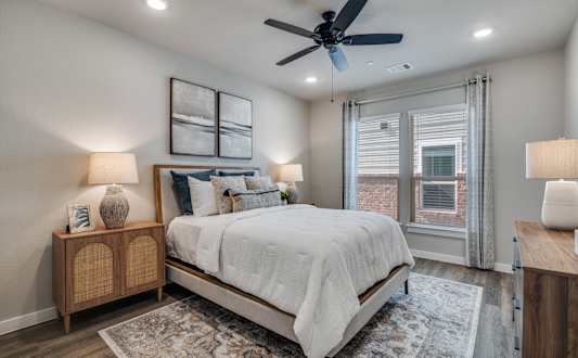 A bedroom with a bed, a ceiling fan, and a rug.