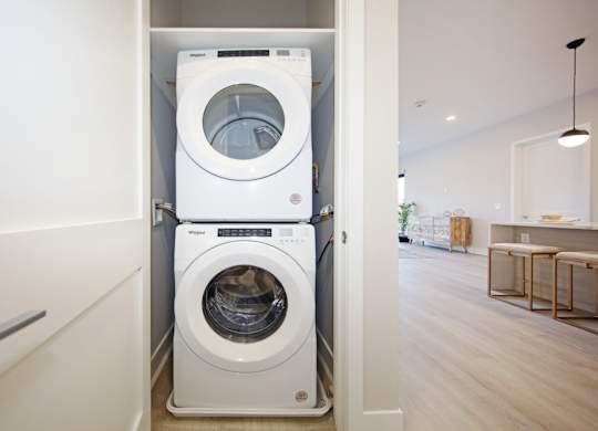 A white front loading washing machine in a laundry room.