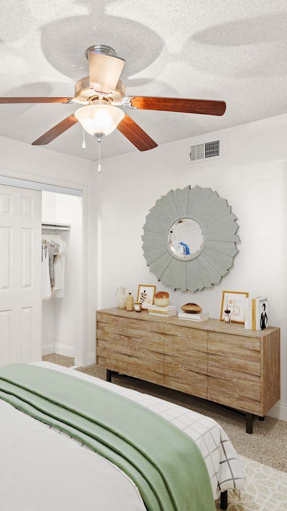 A bedroom with a bed, dresser, and mirror.
