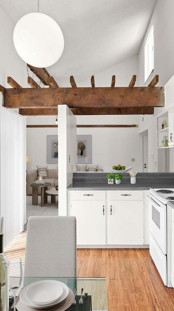 A modern kitchen with white cabinets and a wooden beam.