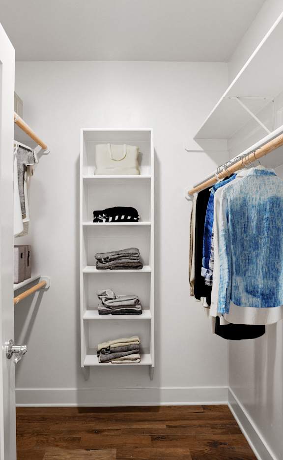A spacious walk-in closet with built-in shelves, shoe storage, and clothing racks.