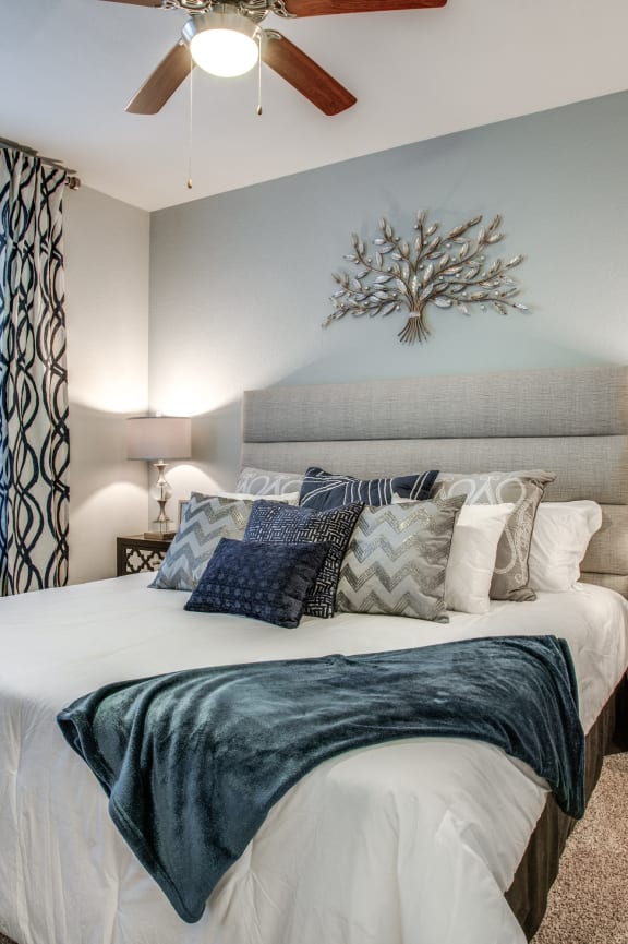 a bedroom with a large bed and a ceiling fan