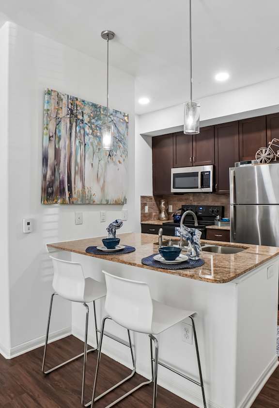 A kitchen with white cabinets and a wooden island.