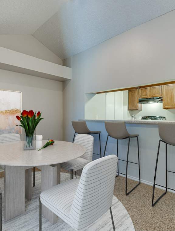 A dining room with a white table and chairs.