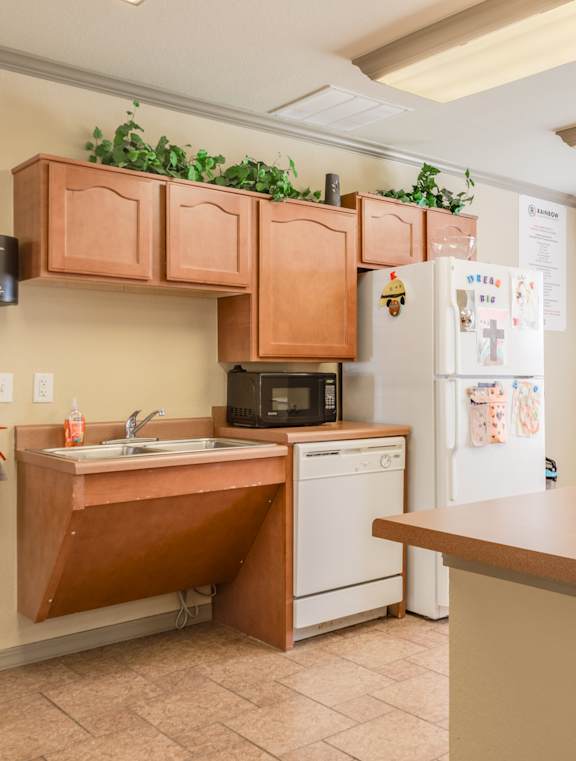 A kitchen with a red kettle on the counter.