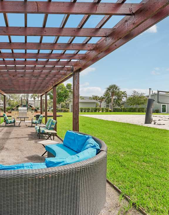 A patio with a hot tub and a pergola.