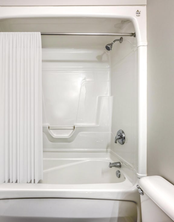 a small bathroom with a white tub and shower
