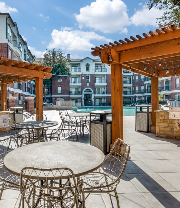 an outdoor patio with tables and chairs and a pool