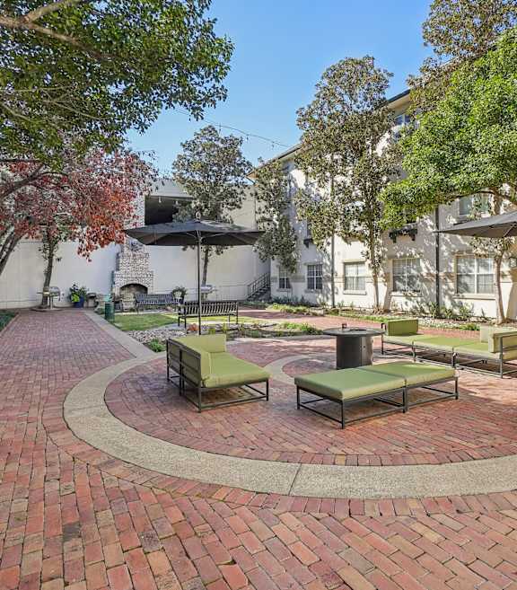 A courtyard with a circular brick patio and benches.