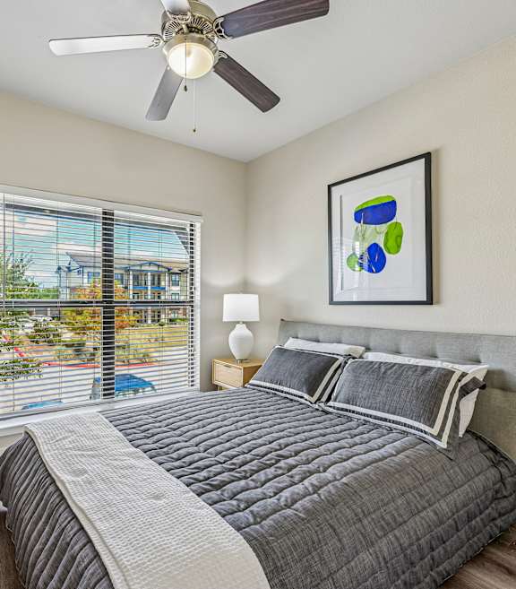 A bedroom with a large bed and a potted plant.