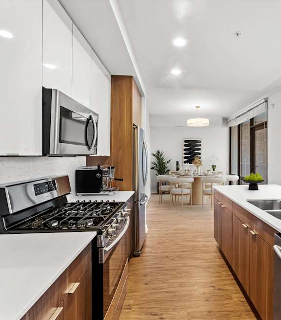 A modern kitchen with white cabinets and stainless steel appliances at Chateau on Wells, Chicago, Illinois