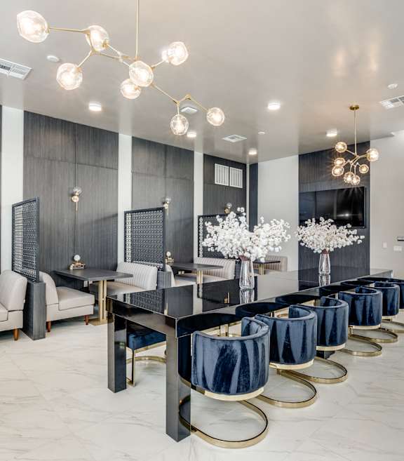 A modern dining room with a long table set for a meal.