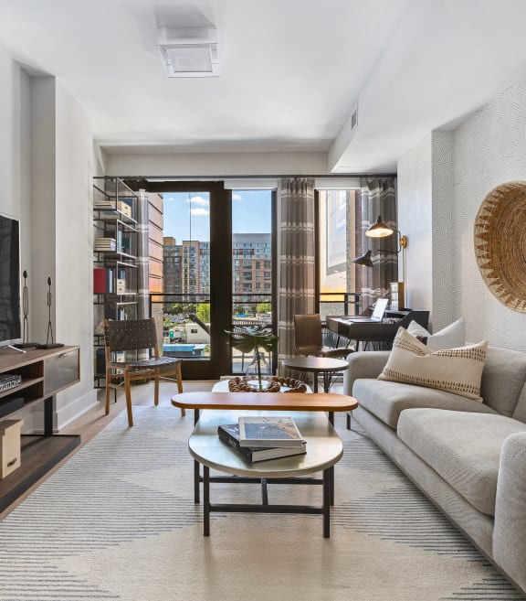 a living room with a couch and a coffee table and a television at Tribeca NOMA apartments