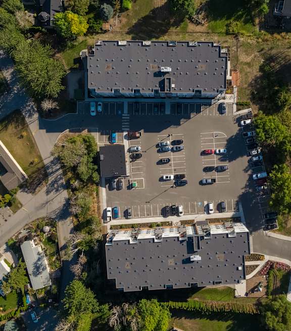 an aerial view of a large building with a parking lot full of cars