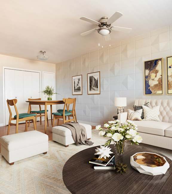 A living room with a white couch, a coffee table, and a dining table with chairs.