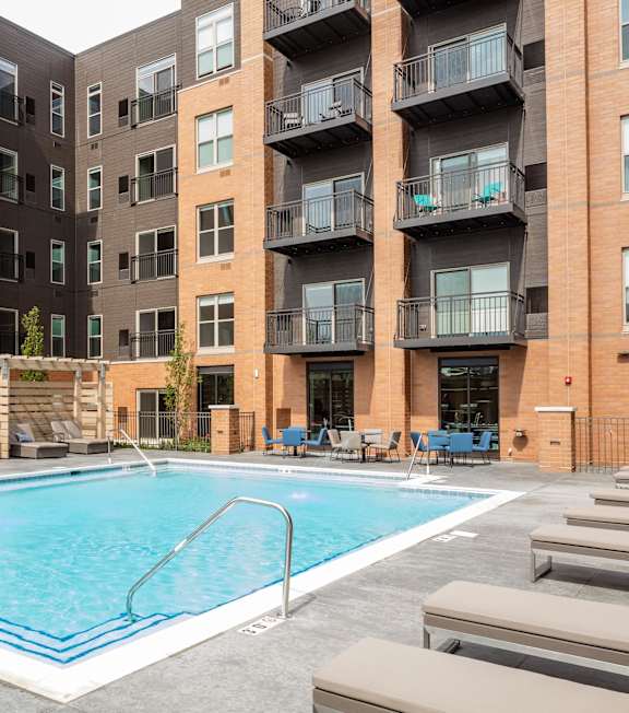 A swimming pool in front of apartment buildings.