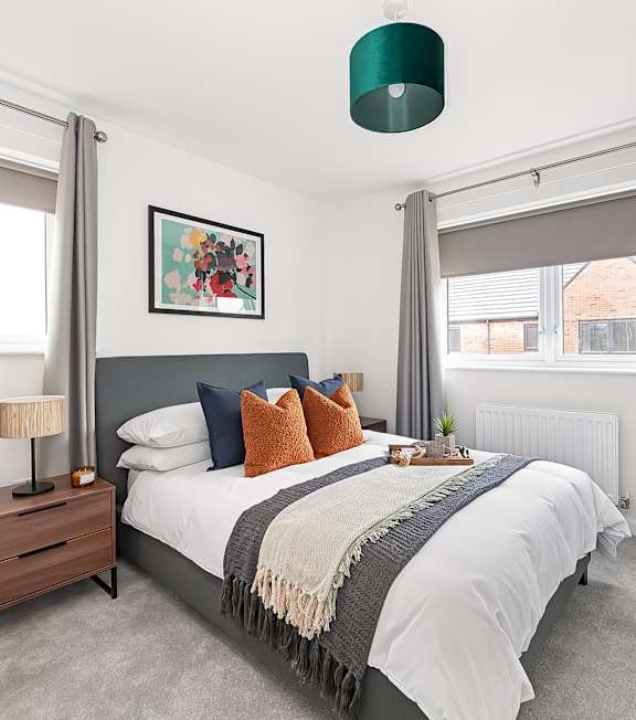 a bedroom with a bed and a large window at The Woodlands Apartments, Milton Keynes