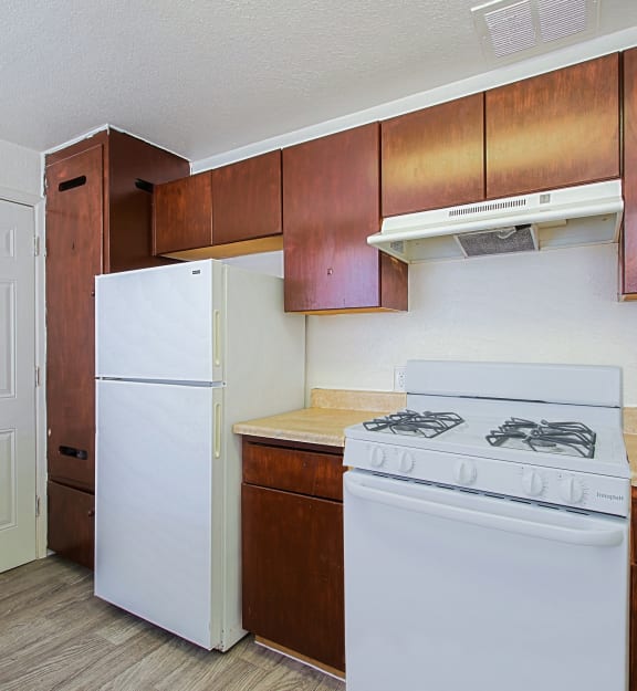 a kitchen with white appliances and wooden cabinets