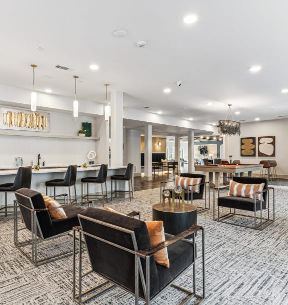 a large lobby with chairs and tables and a bar
