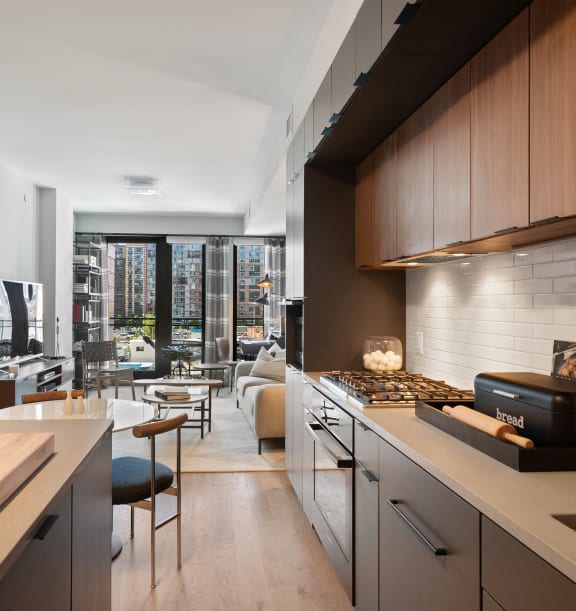a kitchen with wooden cabinets with a view of a living room and terrace in Tribeca NOMA apartments