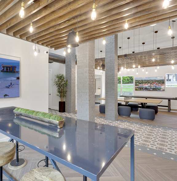 A modern dining area with a glass table and stools.