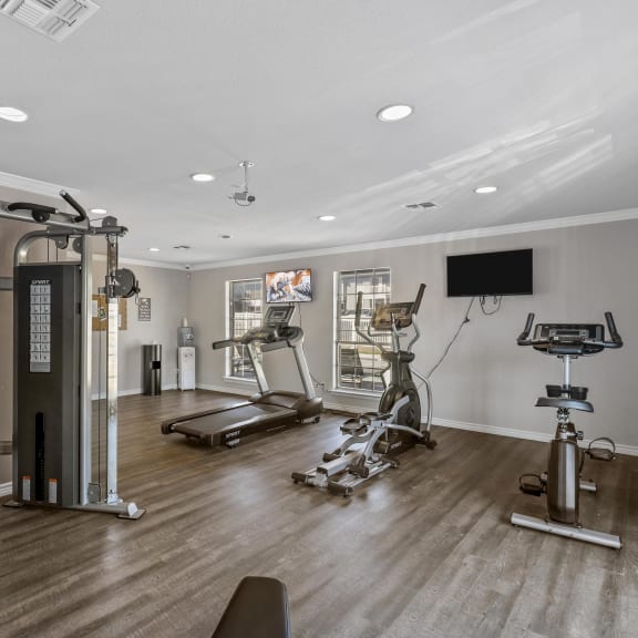 a home gym with exercise equipment and a tv