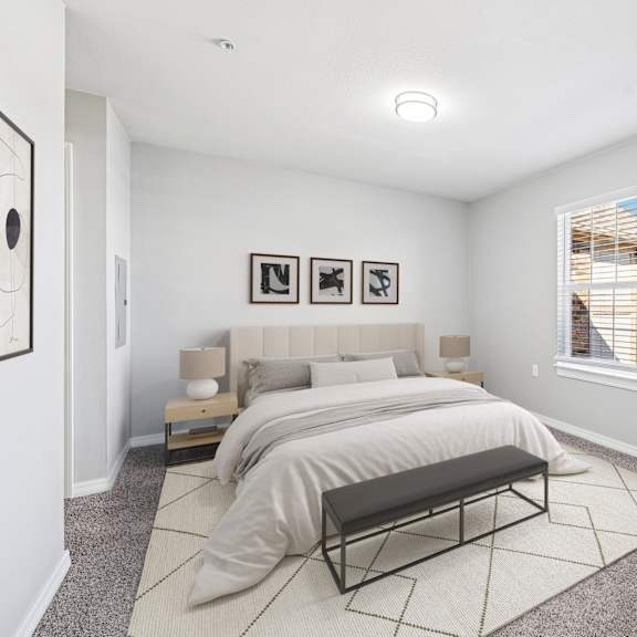 A bedroom with a large bed and a bench in front of it.