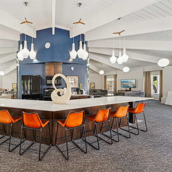 A large conference room with a long table and orange chairs.