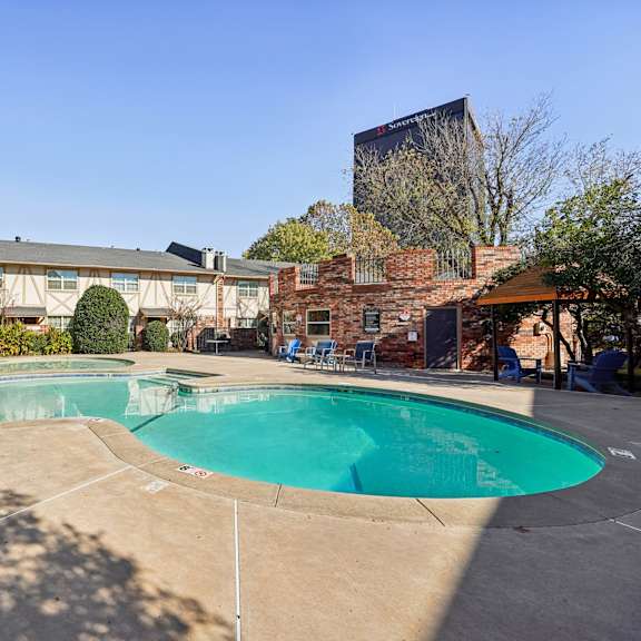 A swimming pool surrounded by a brick building.