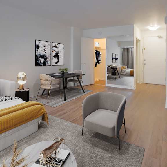 A living room with a grey couch, a round table, and a television.